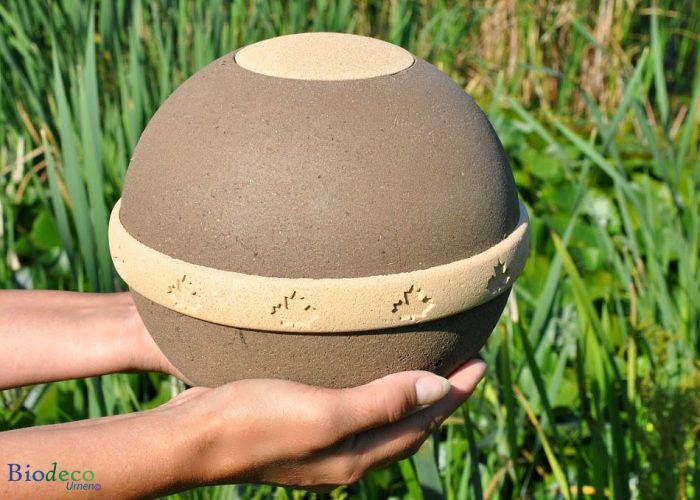 Biologisch afbreekbare eco-urn Geos, de uit plantaardige materialen vervaardigd, op handen gedragen. Asbijzetting in de aarde