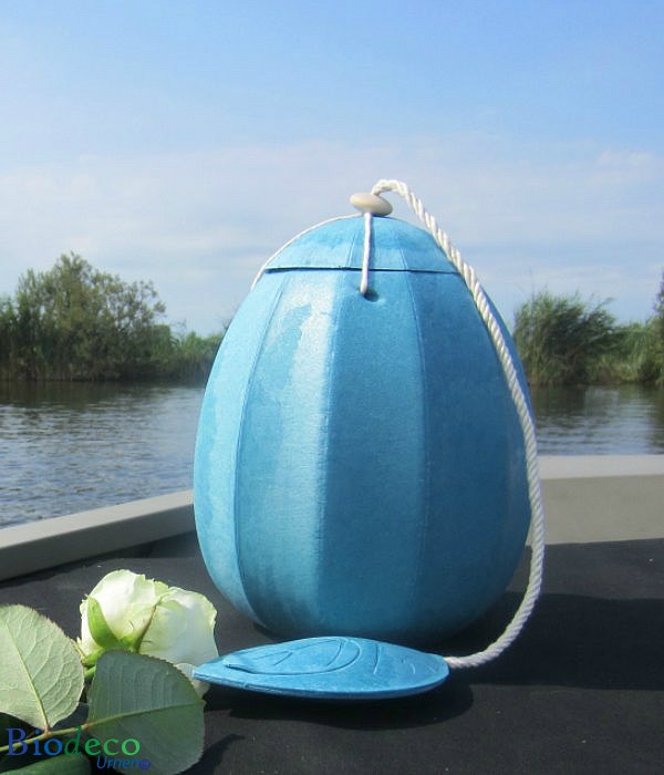 De zee-urn Beyond in het lichtblauw, opgesteld op het voordek van een boot, voor een asbijzetting in het water