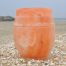 Zee-urn van Himalaya steenzout op het strand van Scheveningen, met de havenhoofden in de Noordzee op de achtergrond
