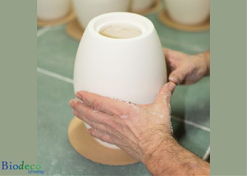 De biologisch afbreekbare zee-urn Okeano, handgemaakt van wit strandzand. Voor een asbijzetting in het water